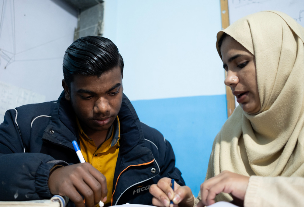 Yashwa Saleem, 15, is in grade 5. He studies with his teacher Iqra Akbar in the non-formal education center in Lahore. Photo Credit: GPE/Sebastian Rich
